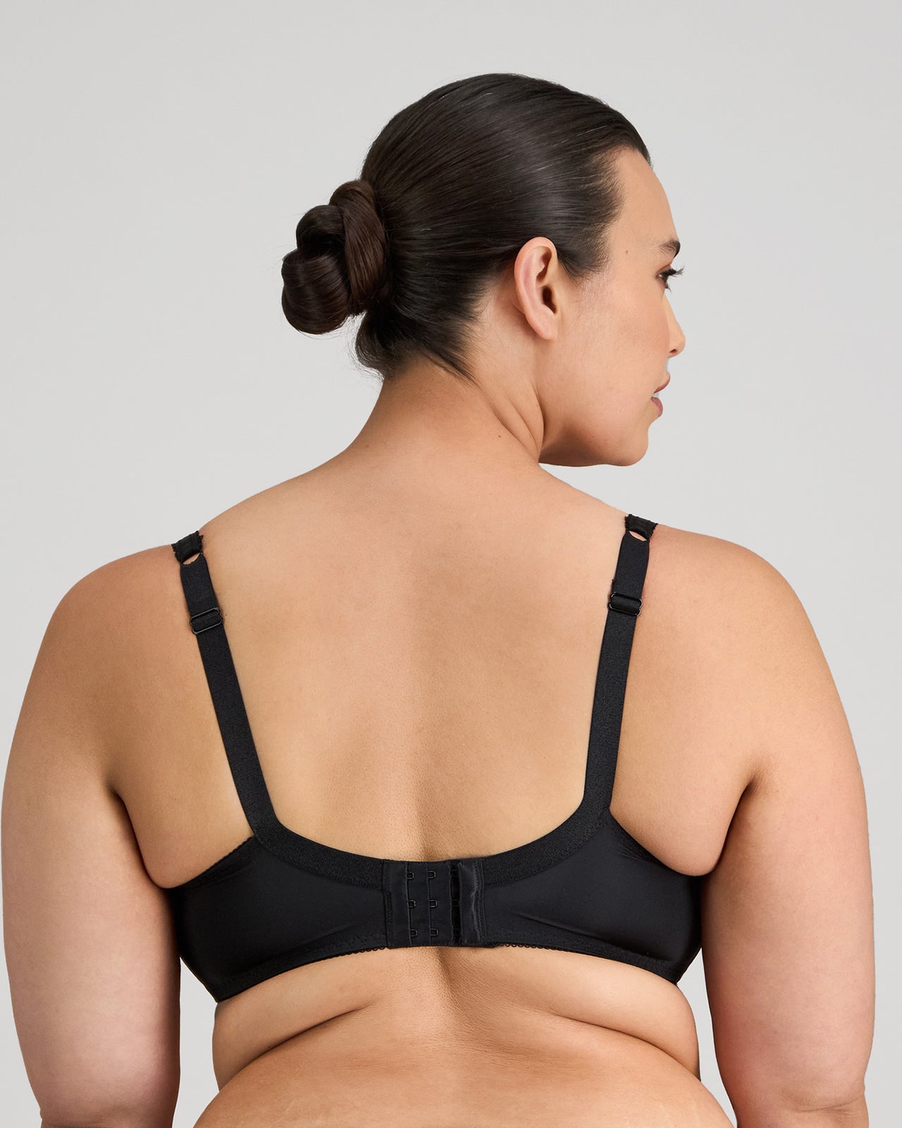 Model wears Delicate Lace Underwire Bra in BLACK/CREAM TAN. On body back view