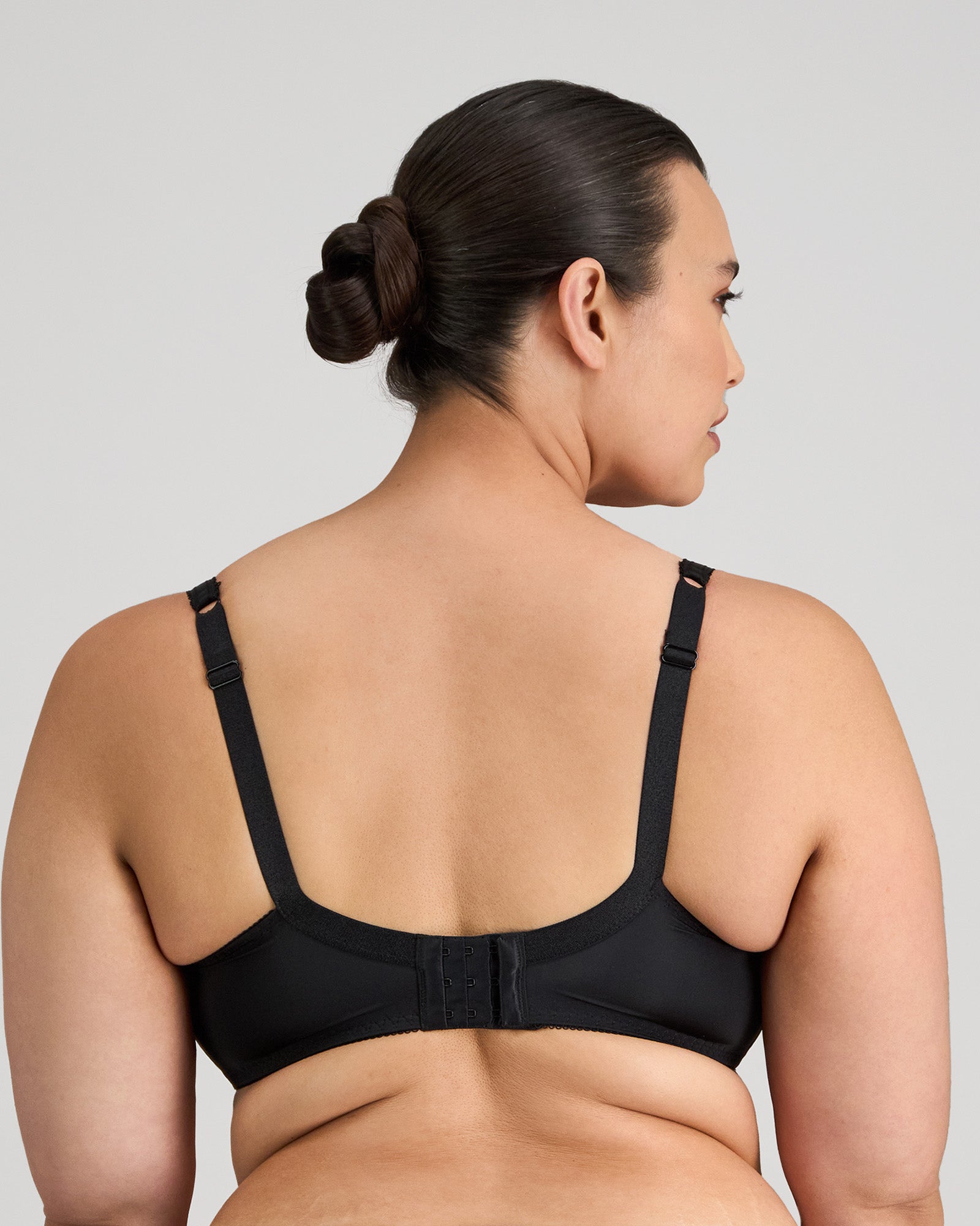 Model wears Delicate Lace Underwire Bra in BLACK/CREAM TAN. On body back view