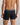 Model wears Everyday Active Mens Long Trunk in BLACK. On body back view