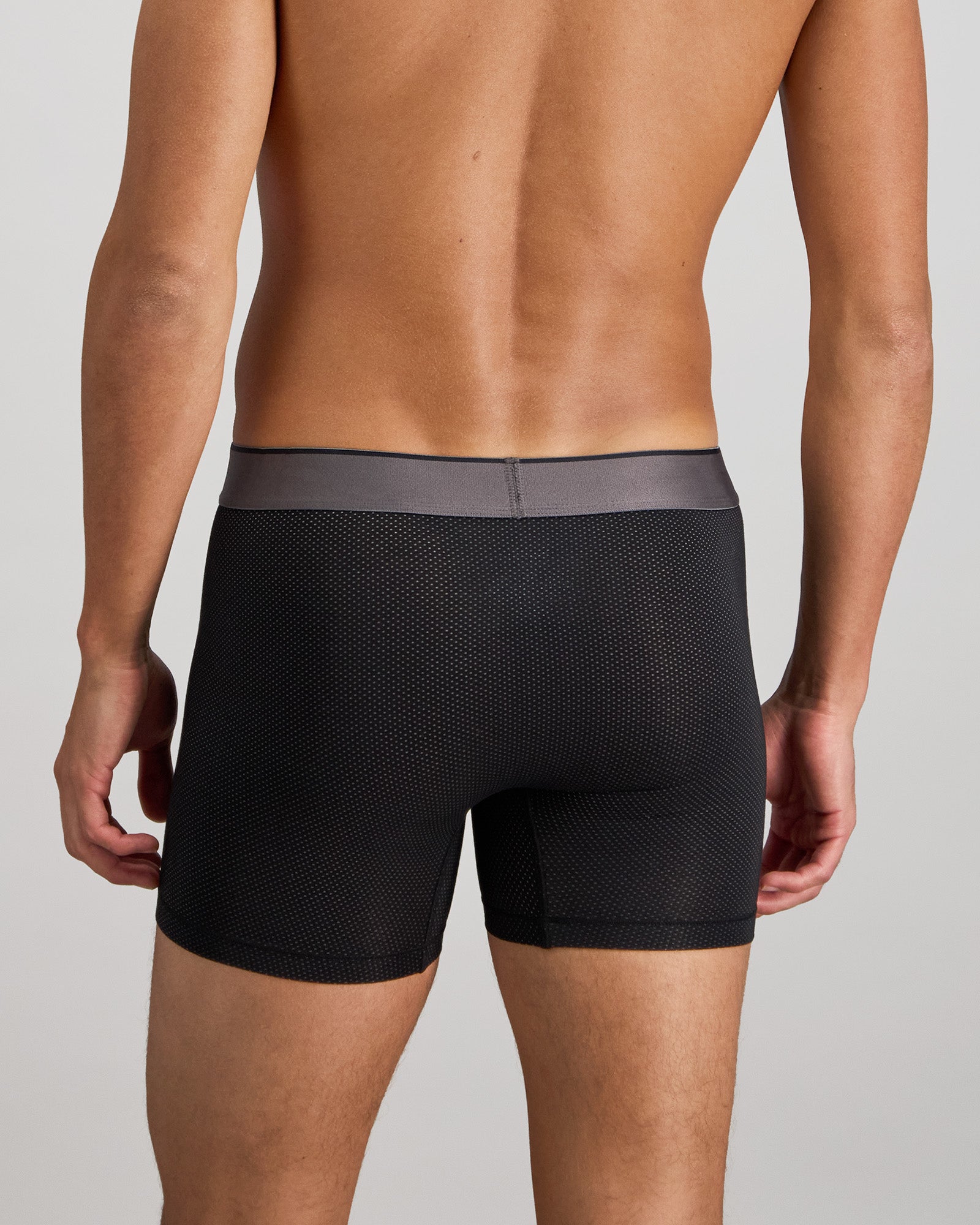 Model wears Everyday Active Mens Long Trunk in BLACK. On body back view
