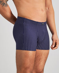 Model wears Cotton Stretch Mens Trunk in PEACOAT PINSTRIPE. On body side view