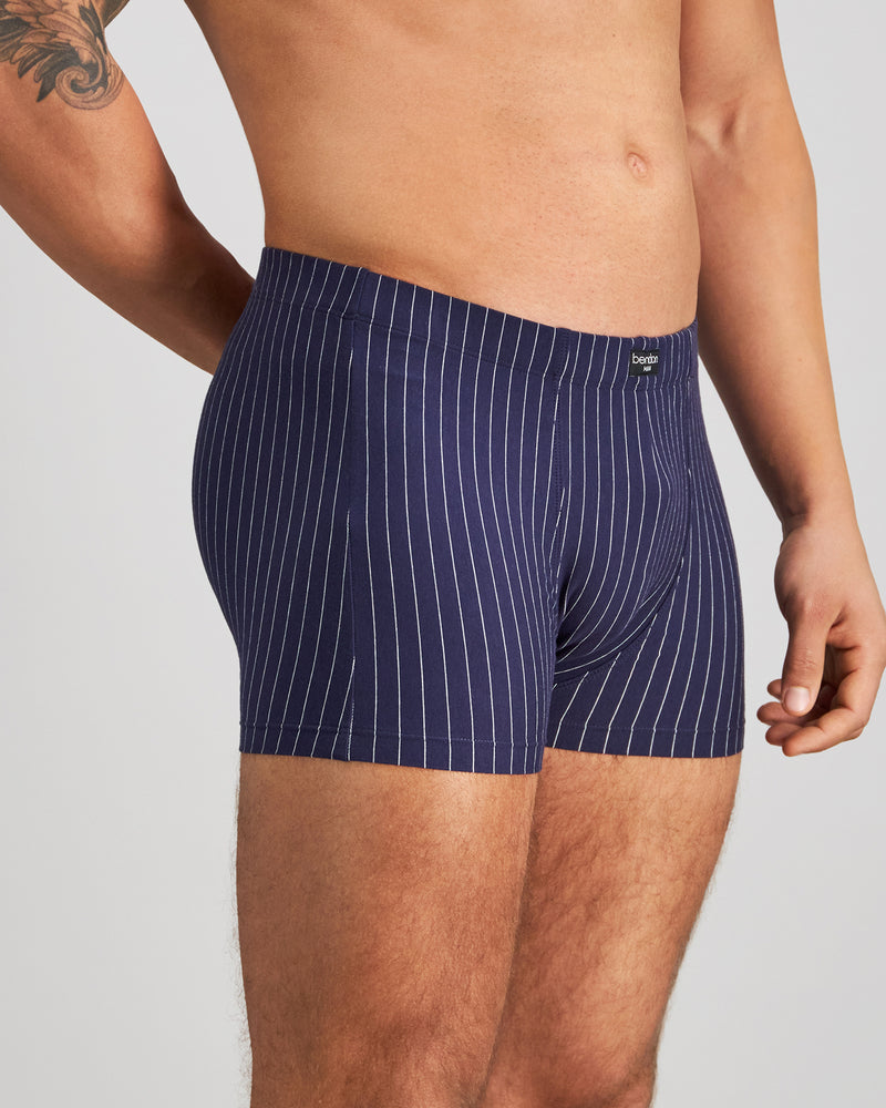 Model wears Cotton Stretch Mens Trunk in PEACOAT PINSTRIPE. On body side view