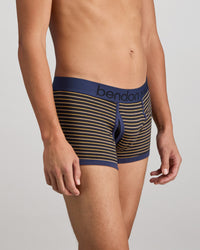 Model wears Bold Stripe Mens Trunk in BLACK/OAK BUFF STRIPE. On body side view