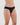 Model wears Seamless Soft Bikini in BLACK. On body side view
