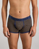 Model wears Bold Stripe Mens Trunk in BLACK/OAK BUFF STRIPE. On body front view