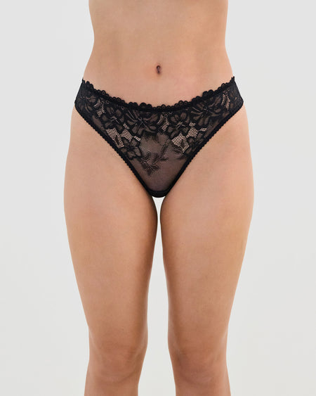 Model wears All Lacey Thong in BLACK. On body front view