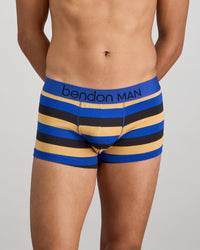 Model wears Rugby Stripe Mens Trunk in BLACK/SURF/OAK BUFF. On body front view