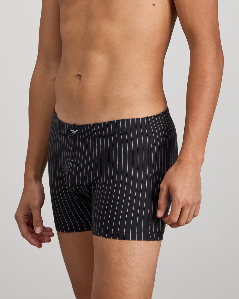 Model wears Cotton Stretch Mens Trunk in BLACK PINSTRIPE. On body side view