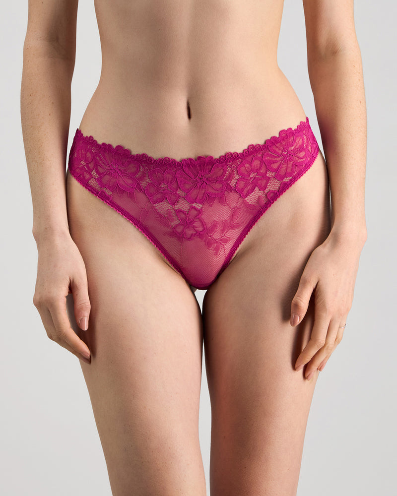 Model wears All Lacey Thong in FANTASY FUCHSIA. On body front view