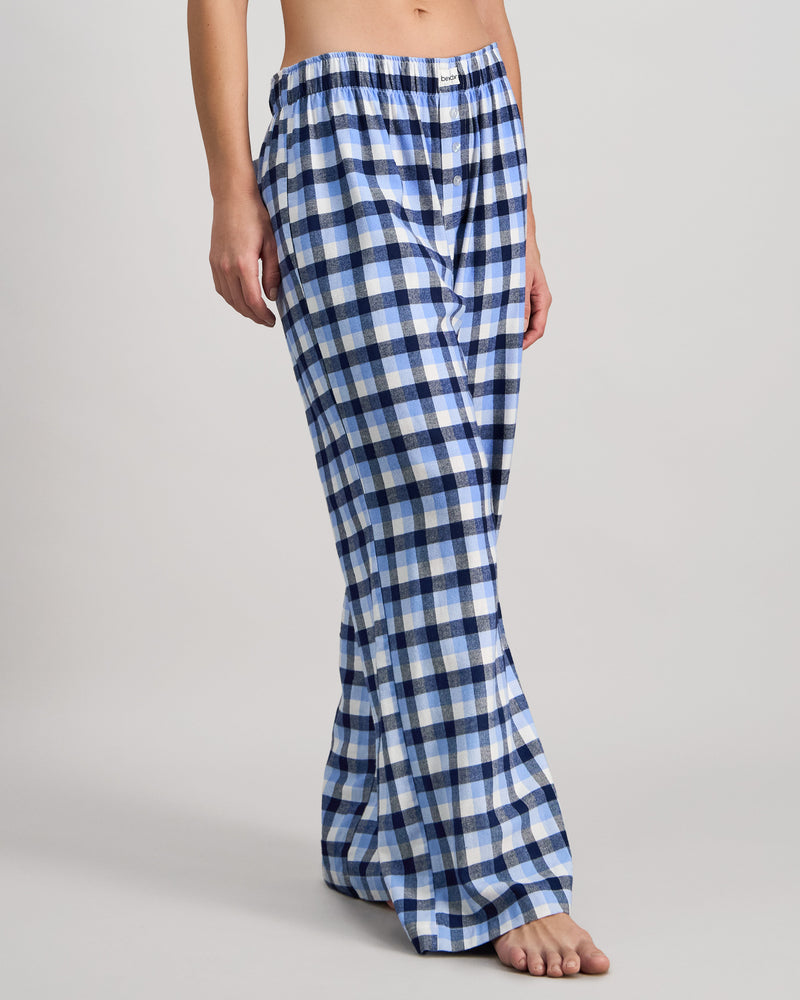 Model wears Cosy Flannel Long PJ Pant in BLUE CHECK. On body side view