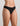 Model wears Extra-Ordinary Thong in BLACK. On body side view