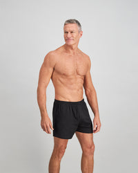 Model wears Cotton Basics Mens Trunk in BLACK. On body side view