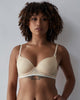 Model wears Geometric Lace Contour Bra in TOASTED ALMOND/PRISTINE. On body front view