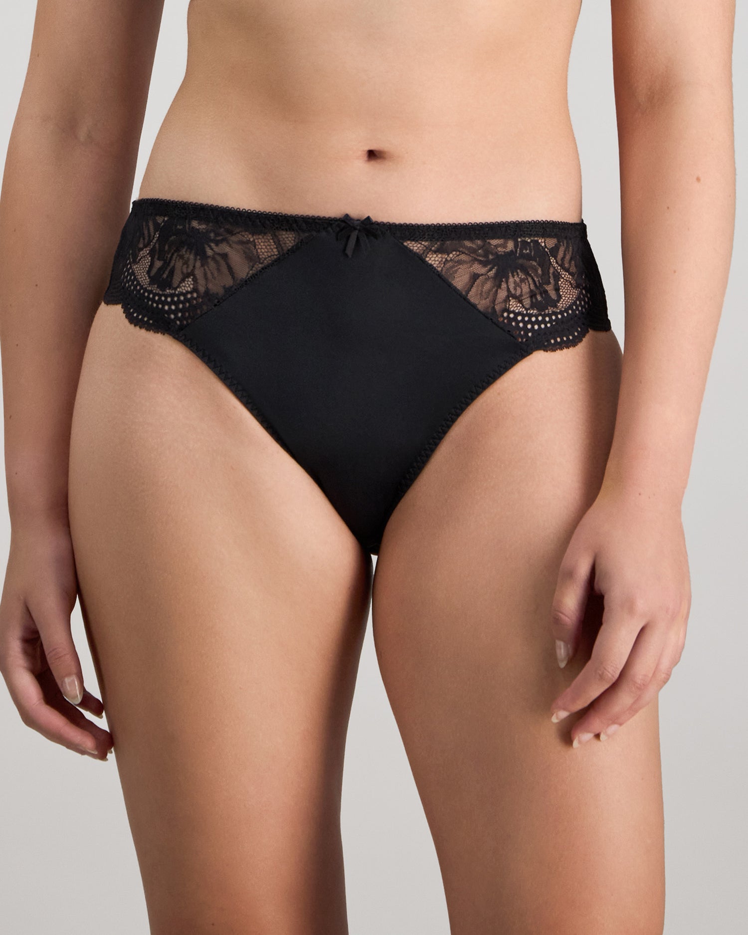 Model wears Aria High Cut Brief in BLACK. On body front view