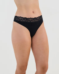 Model wears Cotton And Lace Thong in BLACK. On body side view