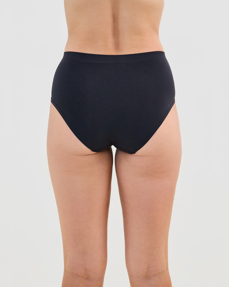 Model wears Seamless Soft Full Brief in BLACK. On body back view