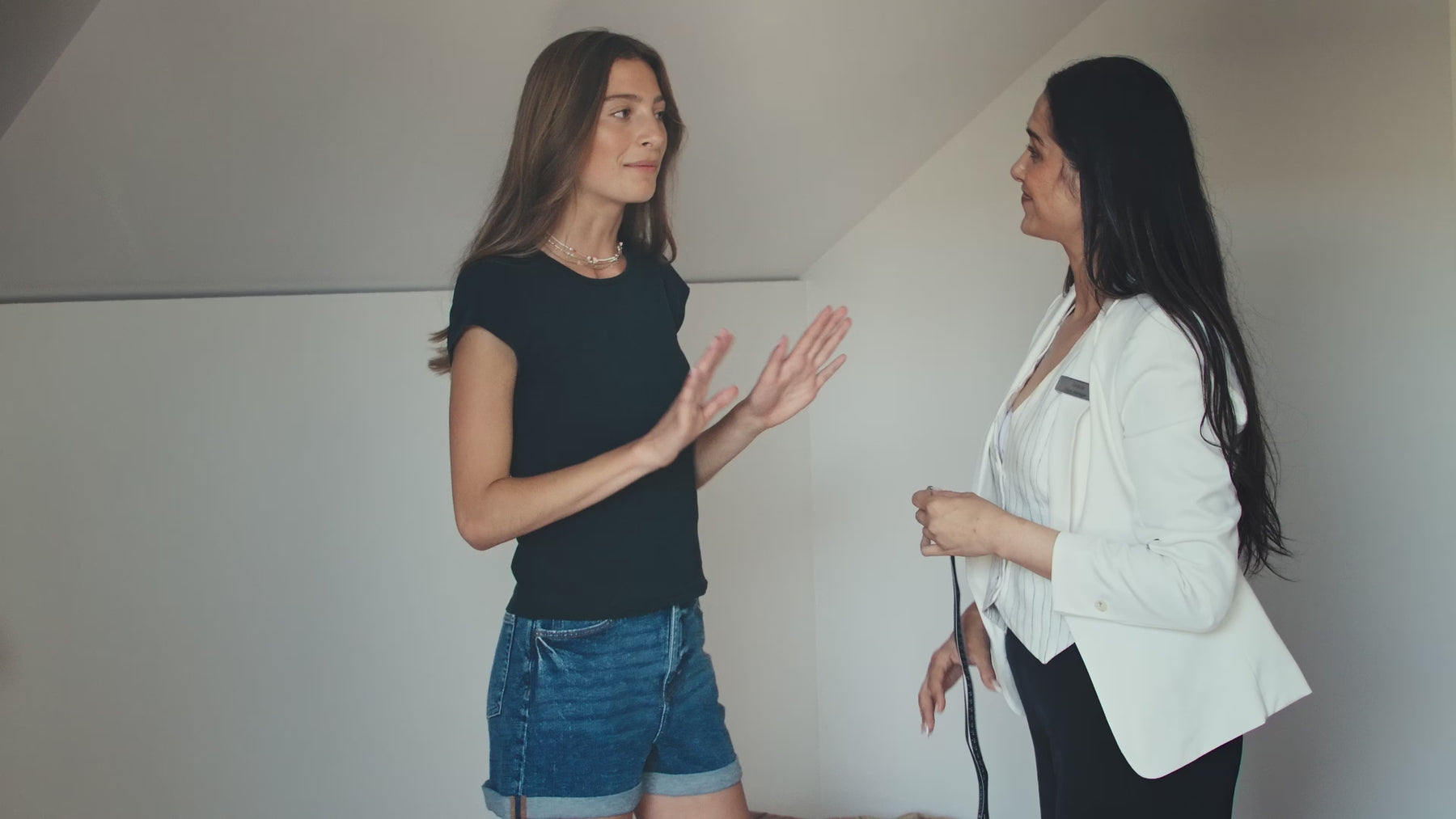 model being measured across bust over a black t-shirt by a staff member